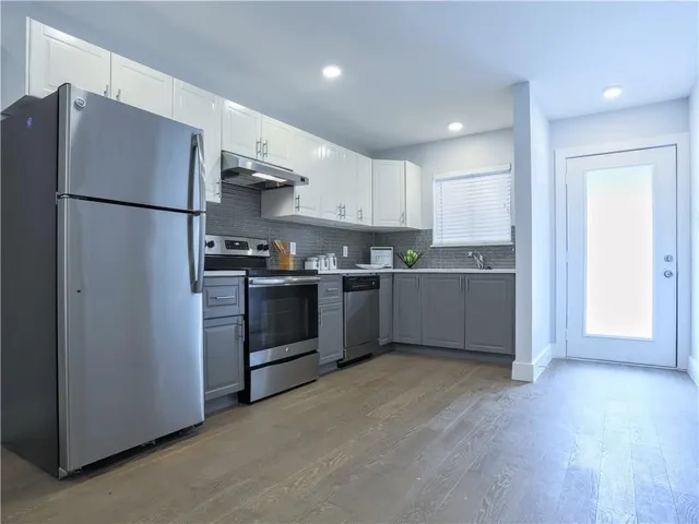 a kitchen with stainless steel appliances granite countertop a refrigerator and a sink
