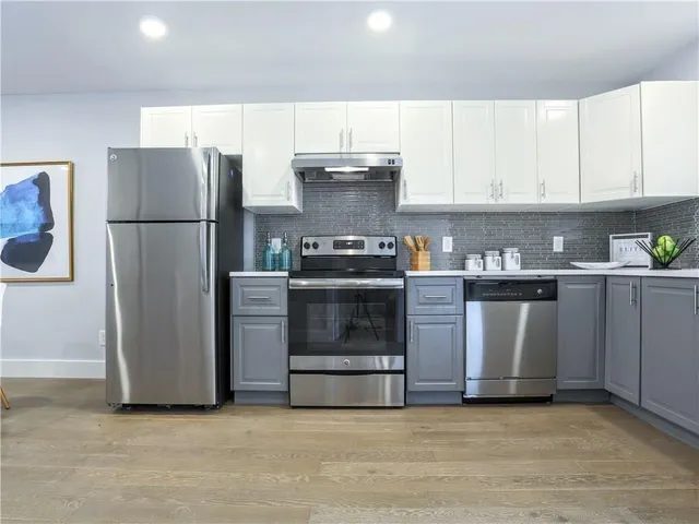 a kitchen with a stove top oven and refrigerator