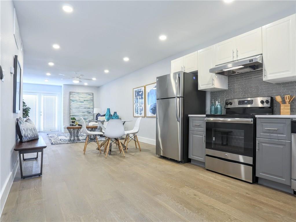 909 Reinli Street, Unit 217 Austin, TX 78751 - Photo 8 of 22 a living room with furniture a fireplace and kitchen view