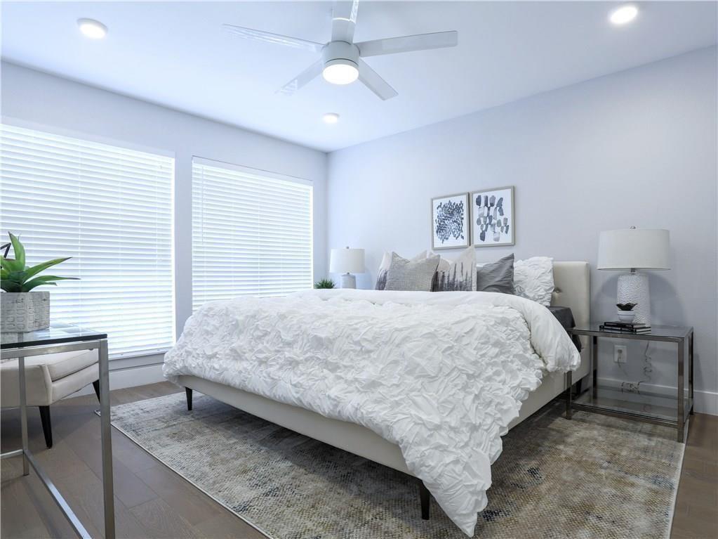 909 Reinli Street, Unit 217 Austin, TX 78751 - Photo 10 of 22 a bedroom with a bed and a chandelier