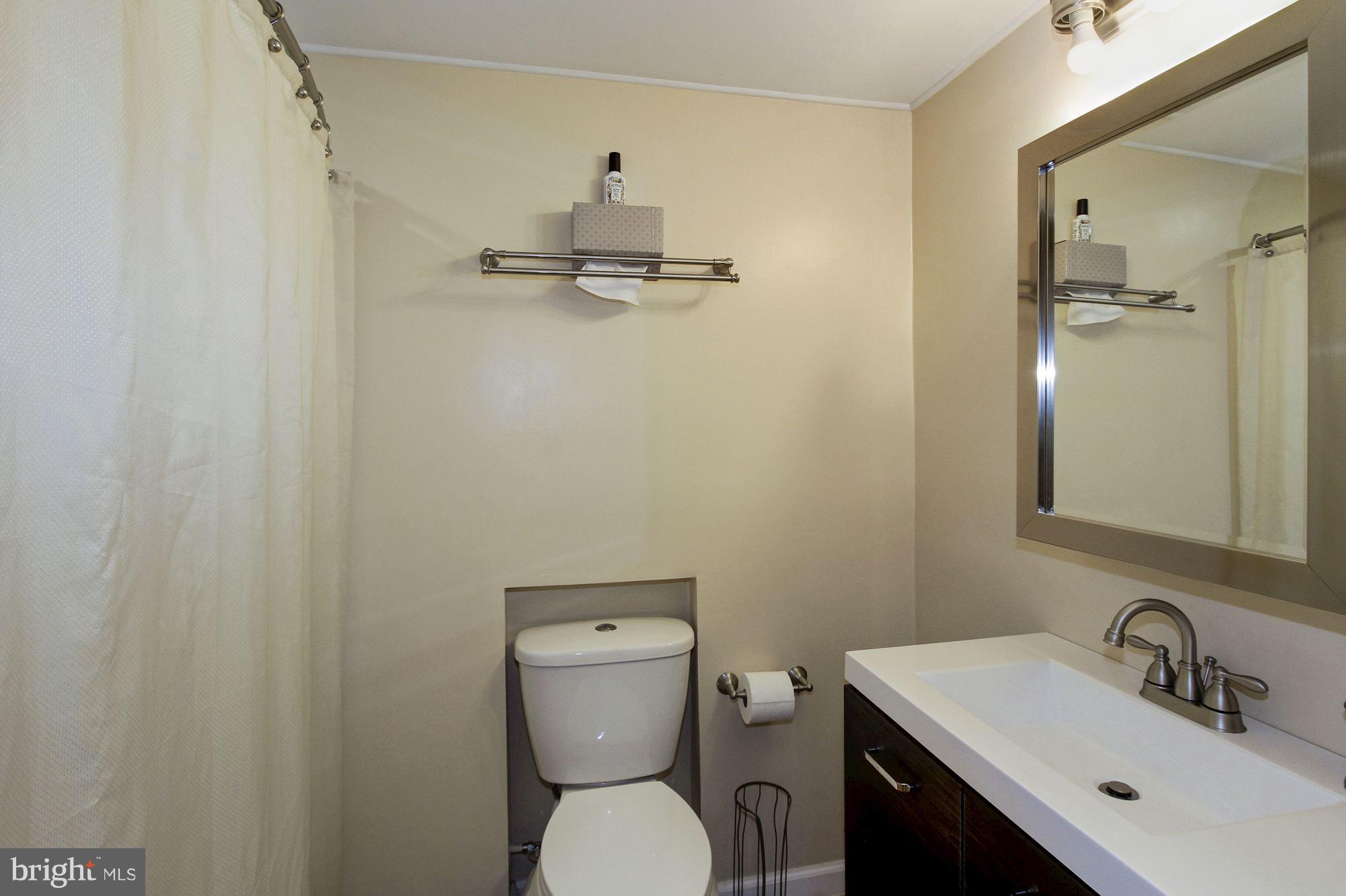 14804 Stonegate Terrace Silver Spring, MD 20905 - Photo 22 of 30 a bathroom with a toilet a sink and mirror