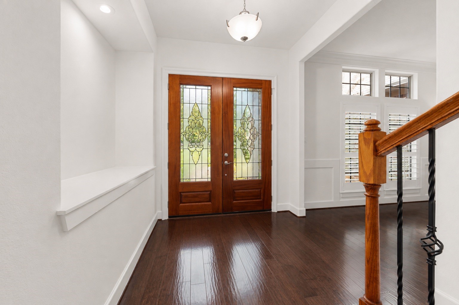 1904 Boulder Ridge Drive Conroe, TX 77304 - Photo 13 of 37 This bright and expansive entryway makes an unforgettable first impression! The double wood doors features detailed leaded glass panels. The sophisticated foyer also highlights premium craftsmanship, showcasing an elegant built-in art niche and custom trim work that flows beautifully into the adjoining rooms.