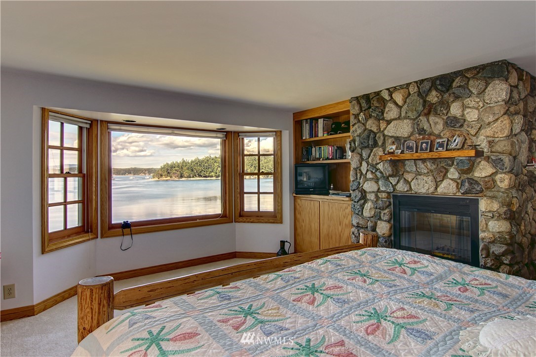 2461 Turn Point Road Friday Harbor, WA 98250 - Photo 9 of 25 a bedroom with a bed and a fireplace