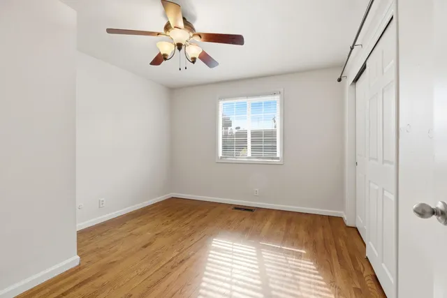 a view of empty room with wooden floor