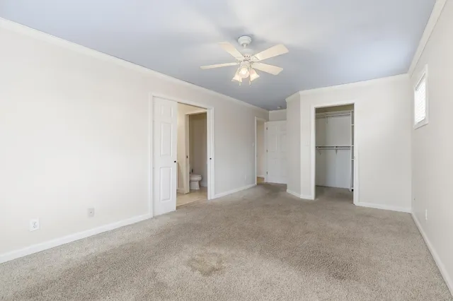 a view of an empty room with chandelier fan