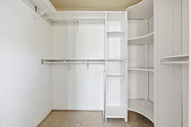 a view of walk in closet with empty racks