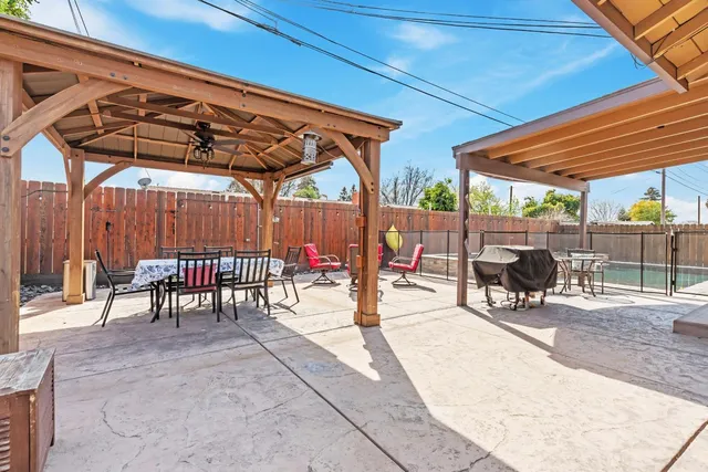 a view of a patio with a table and chairs under an umbrella