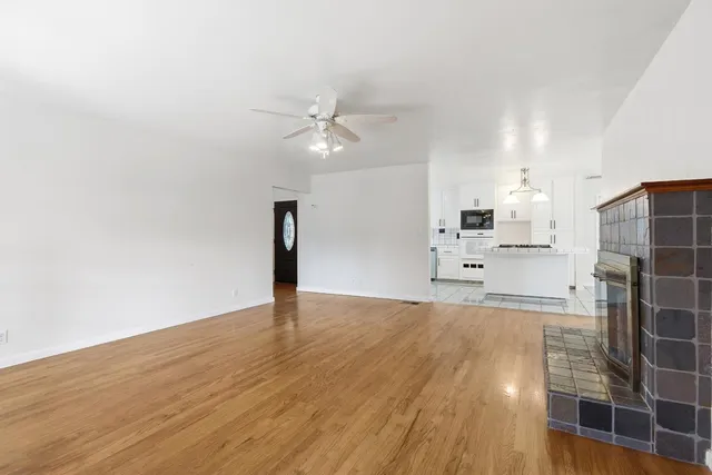 a view of a kitchen with wooden floor and a ceiling fan