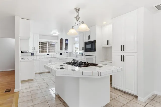 a kitchen with stainless steel appliances a stove a sink and a refrigerator