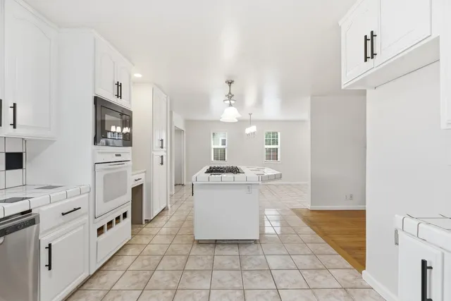 a kitchen with stainless steel appliances a stove refrigerator and cabinets