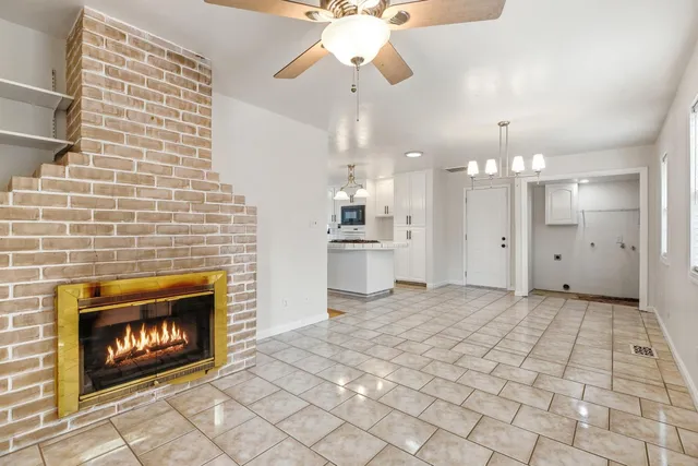 a view of a kitchen with a fireplace and a chandelier fan