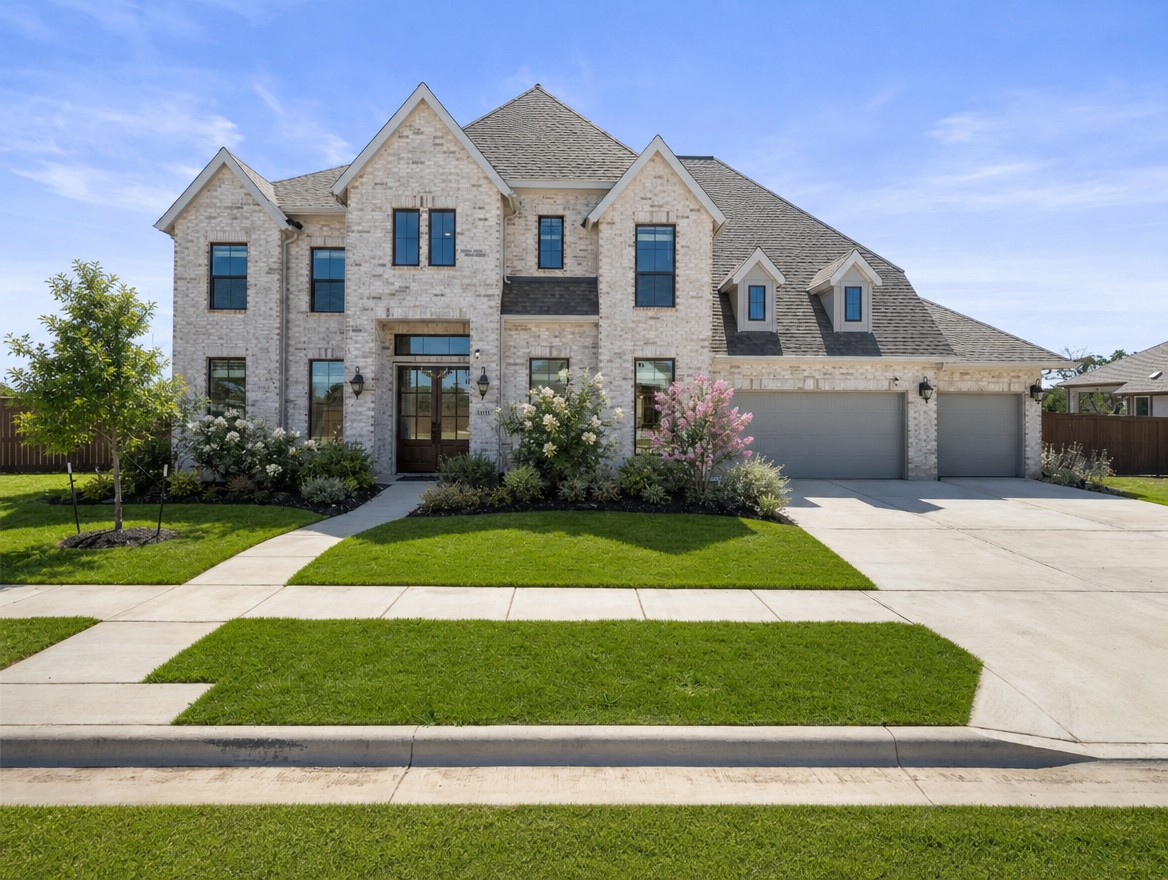 1440 Riva Ridge Drive Leander, TX 78641 - Photo 37 of 37 A stately residence presents a symmetrical facade of light-colored brick, complemented by a broad concrete driveway and verdant landscaping.