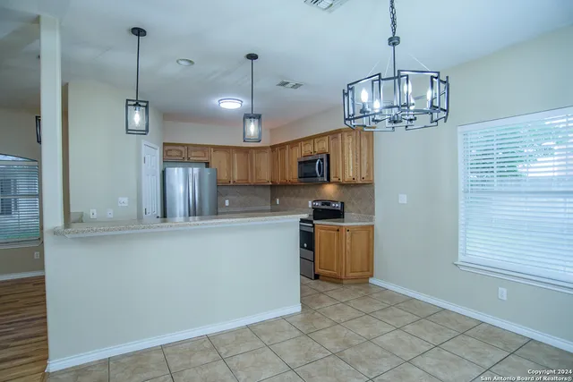 a kitchen with stainless steel appliances granite countertop a refrigerator a stove a sink dishwasher a kitchen island a cabinets and wooden floor