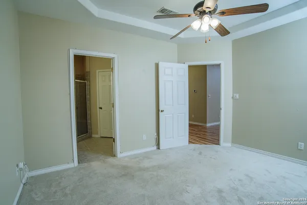 an empty room with closet and a ceiling fan
