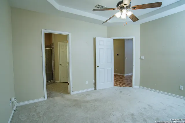 an empty room with closet and a ceiling fan