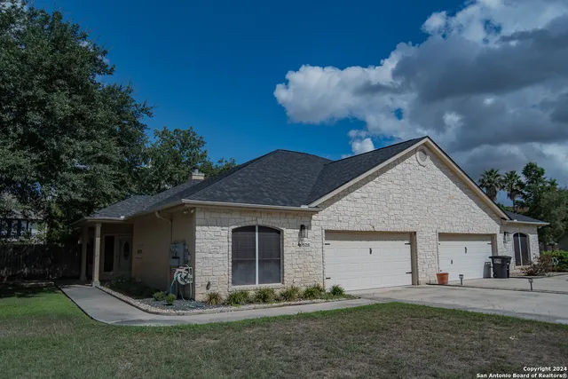 a view of a yard in front of a house with large tree