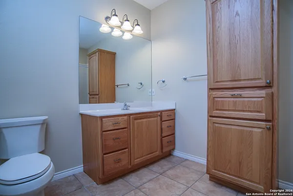 a bathroom with a toilet a sink and mirror