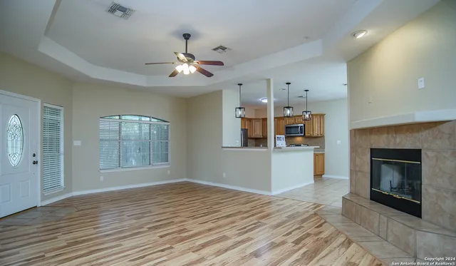 a view of an empty room with a fireplace and a window