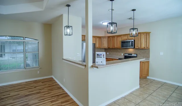a kitchen view with wooden floor and window