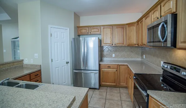 a kitchen with stainless steel appliances granite countertop a refrigerator and a stove