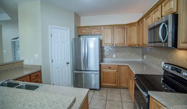a kitchen with stainless steel appliances granite countertop a refrigerator and a stove