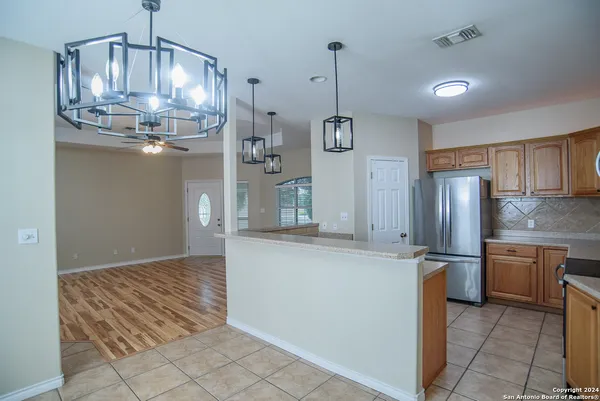 a kitchen with stainless steel appliances granite countertop a sink refrigerator and cabinets