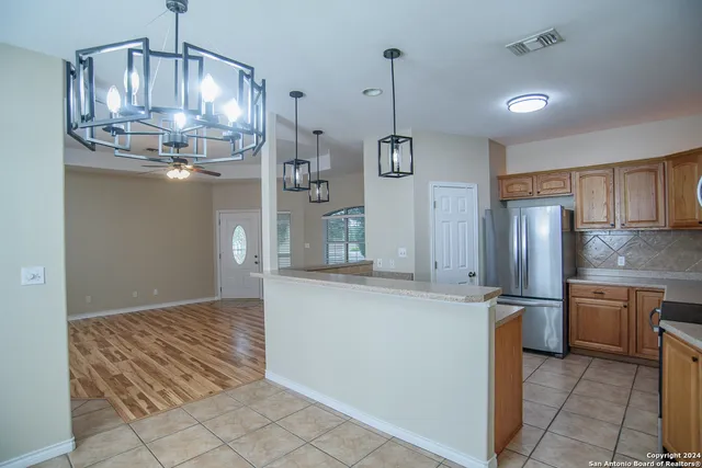 a kitchen with stainless steel appliances granite countertop a sink refrigerator and cabinets