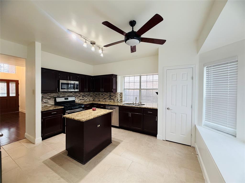 434 Moonlight Way Irving, TX 75063 - Photo 7 of 29 a kitchen with stainless steel appliances granite countertop a stove and a refrigerator