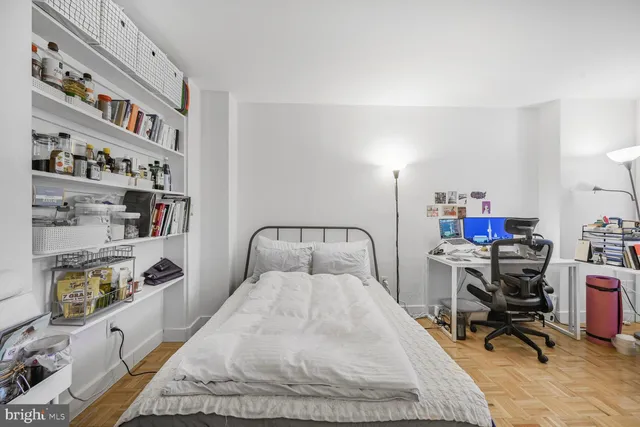 a bedroom with a bed and a bookshelf with wooden floor