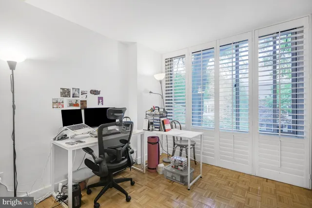 a view of a workspace with furniture and a window