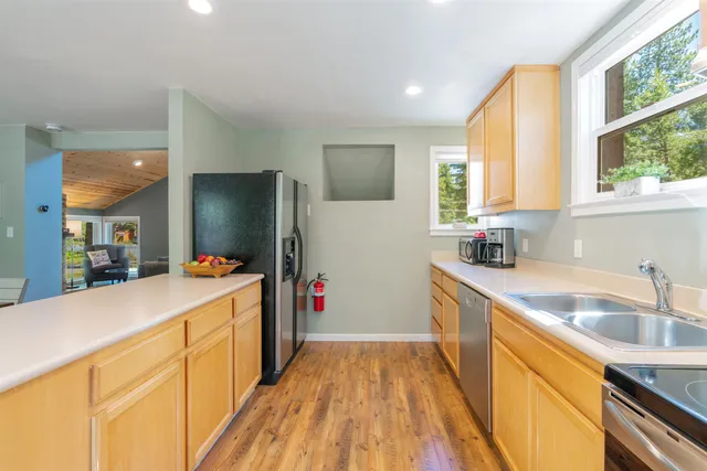 a kitchen that has a sink stove top oven and refrigerator