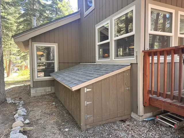 a view of backyard with a tub and wooden fence