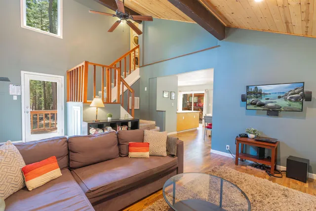 a living room with furniture a flat screen tv and a window