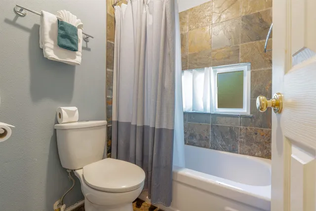 a white toilet sitting next to a bathtub