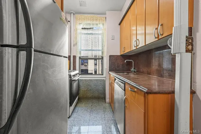 a kitchen with stainless steel appliances granite countertop a refrigerator and a sink