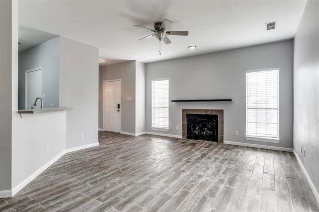 wooden floor fireplace and windows in an empty room