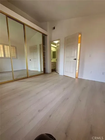 en empty room with wooden floor and mirror