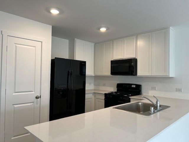 1038 Raintree Road Princeton, TX 75407 - Photo 14 of 36 a kitchen with a refrigerator and a sink