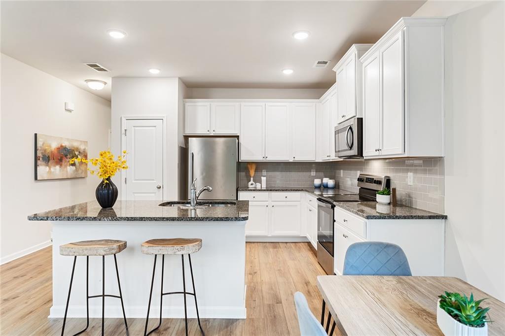 2824 Saratoga Lake View Decatur, GA 30034 - Photo 6 of 29 a kitchen with stainless steel appliances granite countertop a refrigerator a stove a sink dishwasher and white cabinets with wooden floor