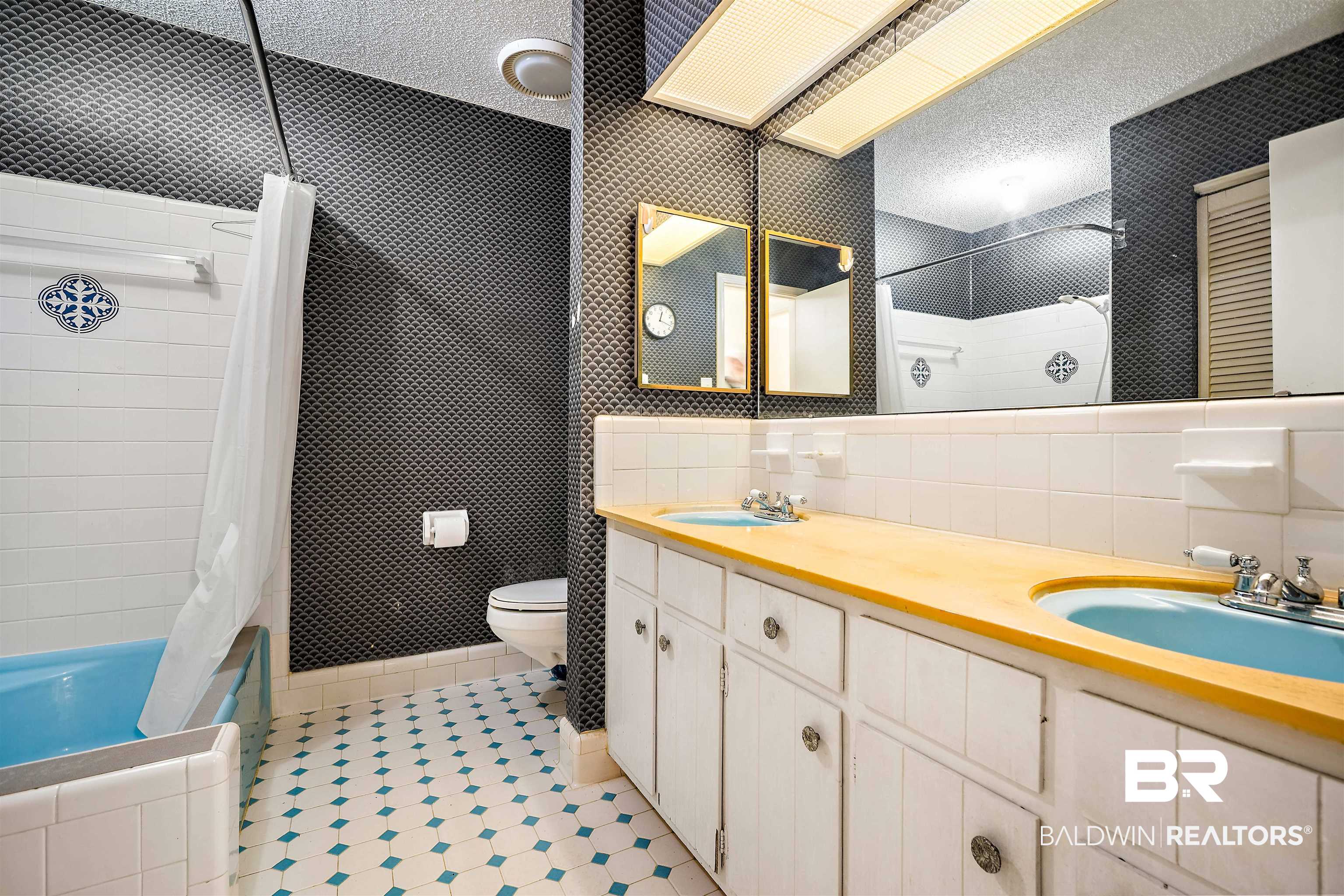 5559 Woodside Drive North Mobile, AL 36608 - Photo 12 of 28 Full bath with tiled shower / bath combo, double vanity, wallpapered walls, a textured ceiling, and light tile patterned flooring