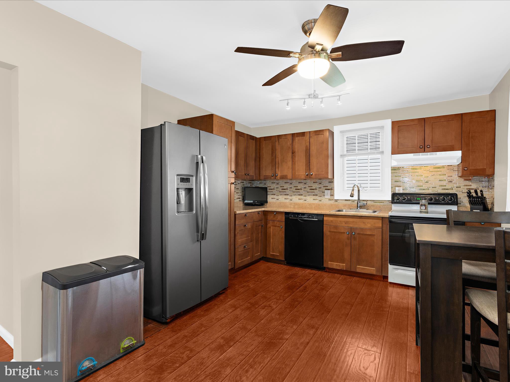 336 Bar Harbor Road Pasadena, MD 21122 - Photo 6 of 82 a kitchen with stainless steel appliances granite countertop a refrigerator a sink dishwasher a stove with wooden floor and cabinets
