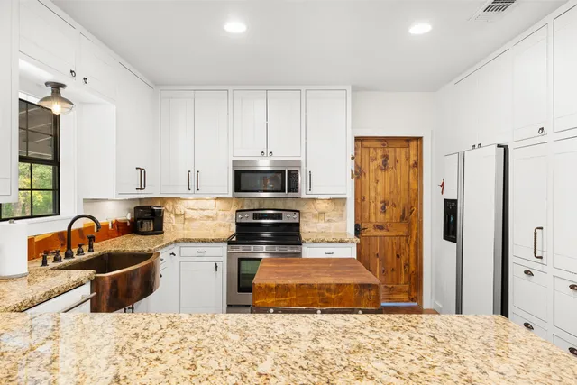 a kitchen with granite countertop sink and cabinets