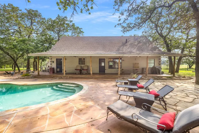 a view of a house with swimming pool and sitting area