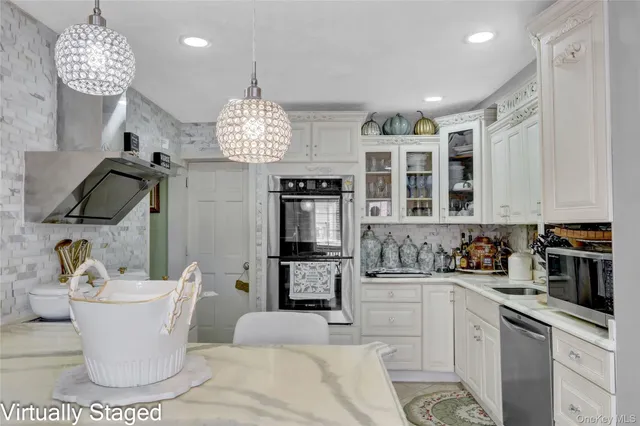 a kitchen with a white cabinets and chandelier