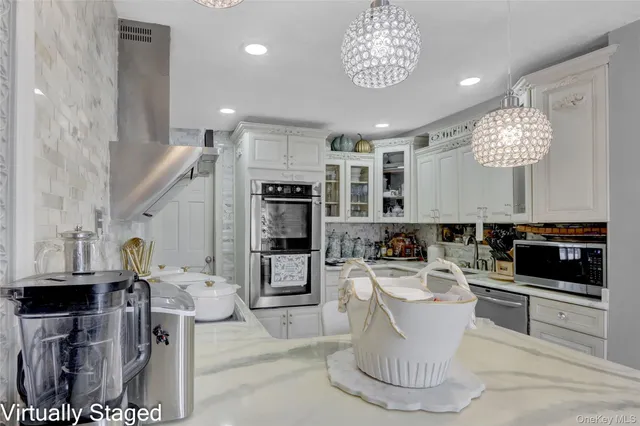 a large white kitchen with a large window and stainless steel appliances