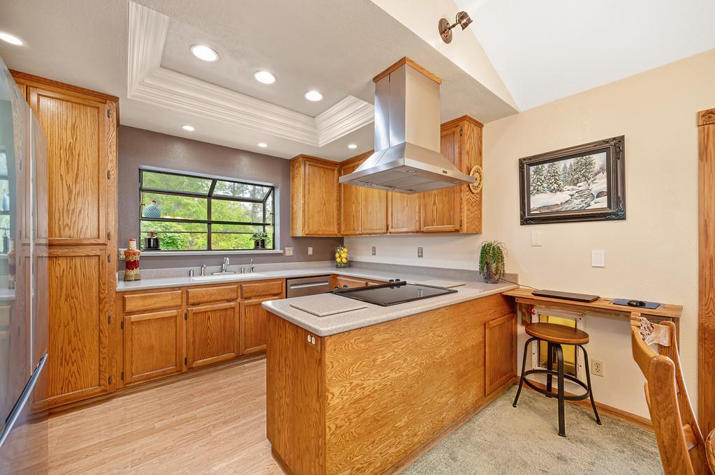 3971 Donner Trail Placerville, CA 95667 - Photo 24 of 78 a kitchen with stainless steel appliances granite countertop wooden cabinets a stove a sink a island and a window