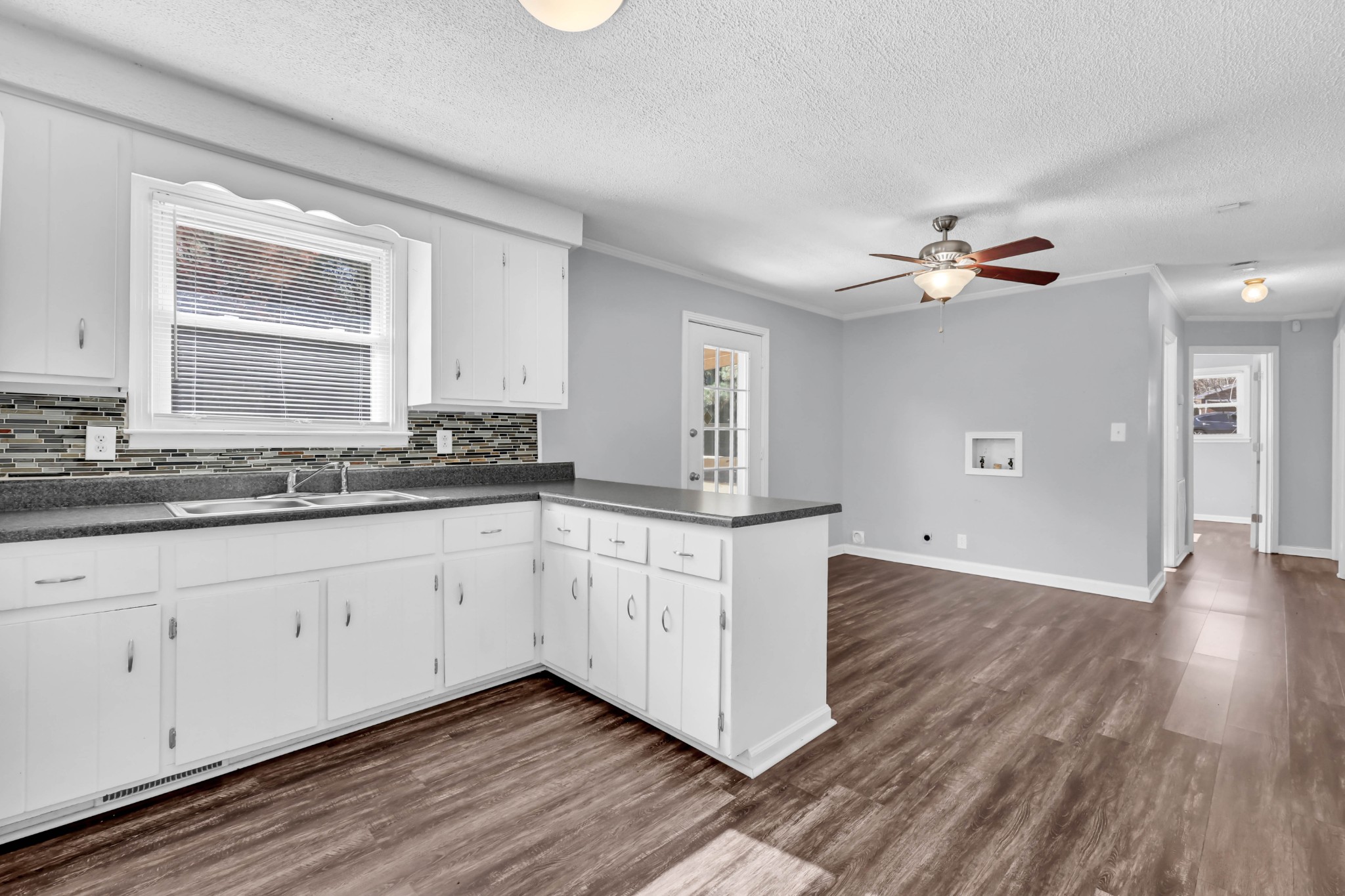 4660 Dover Road Indian Mound, TN 37079 - Photo 9 of 30 a kitchen with granite countertop a stove a sink and white cabinets with wooden floor