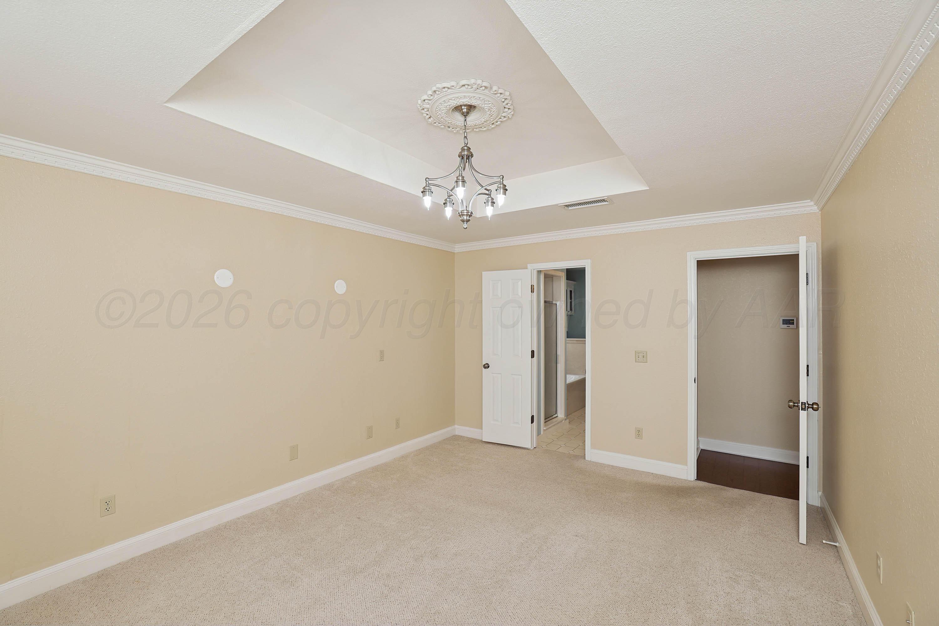 6904 Alpine Lane Amarillo, TX 79109 - Photo 12 of 45 an empty room with a chandelier fan and windows