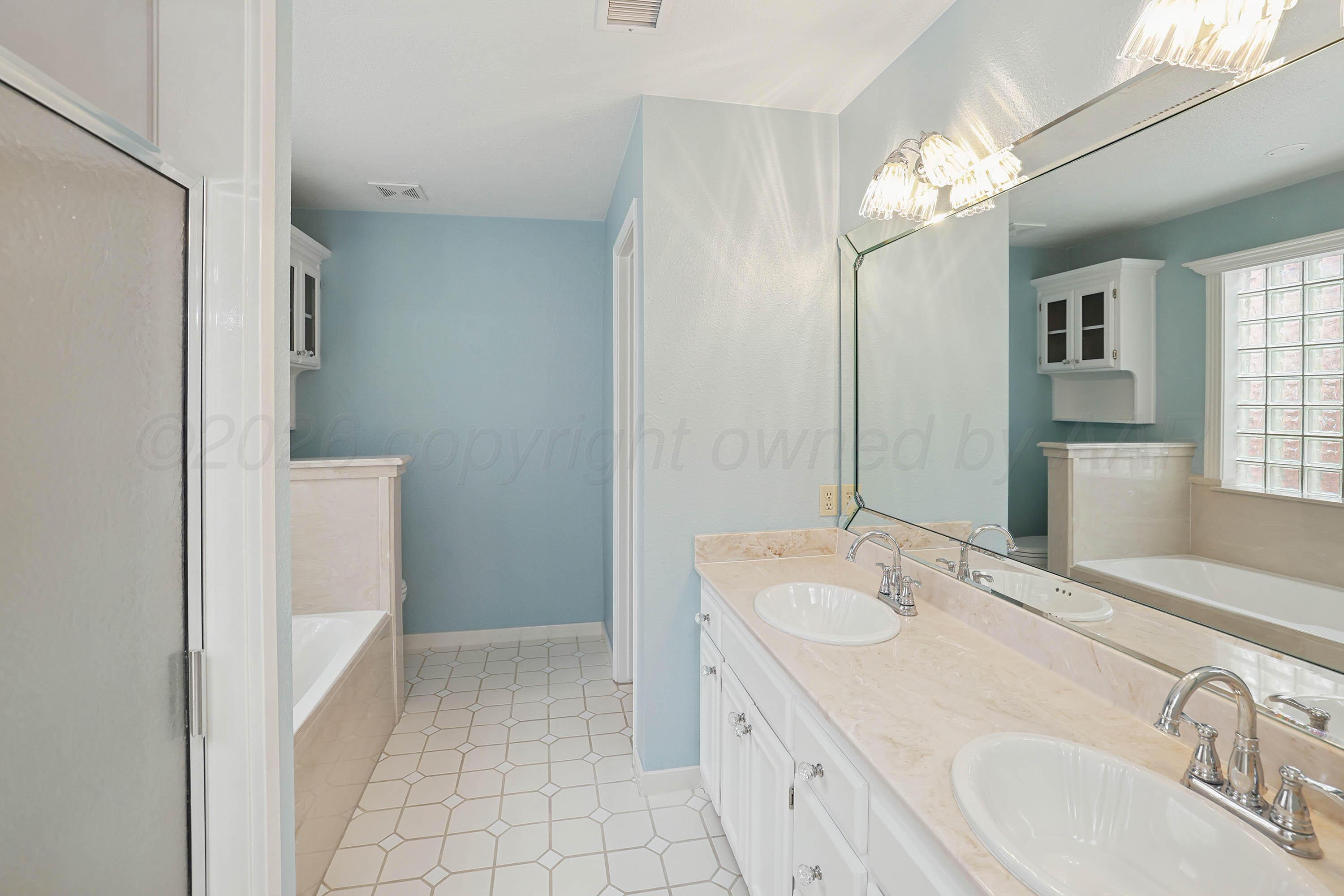 6904 Alpine Lane Amarillo, TX 79109 - Photo 13 of 45 a spacious bathroom with a double vanity sink a mirror and a shower