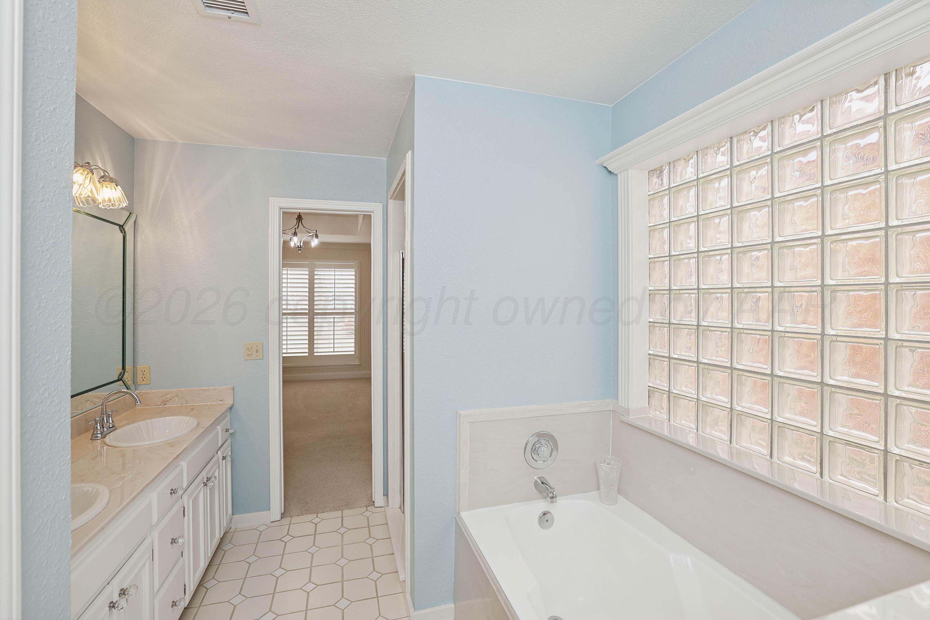 6904 Alpine Lane Amarillo, TX 79109 - Photo 14 of 45 a bathroom with a granite countertop sink a toilet and shower